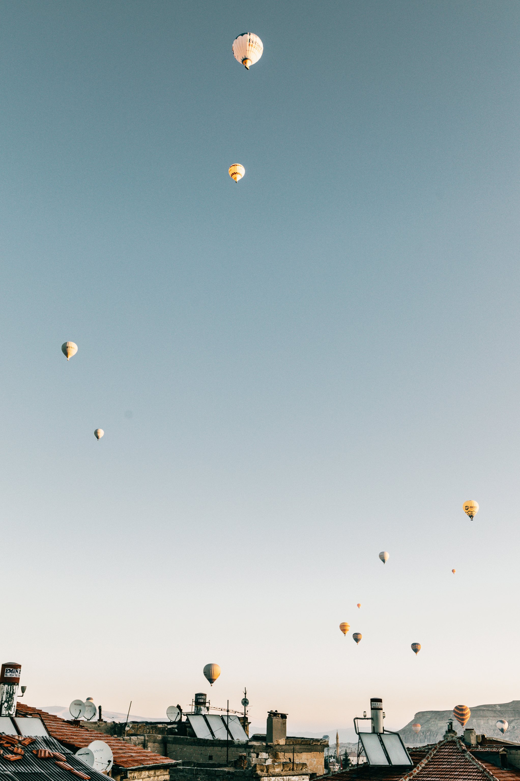 Hot air balloons flying over town in daytime